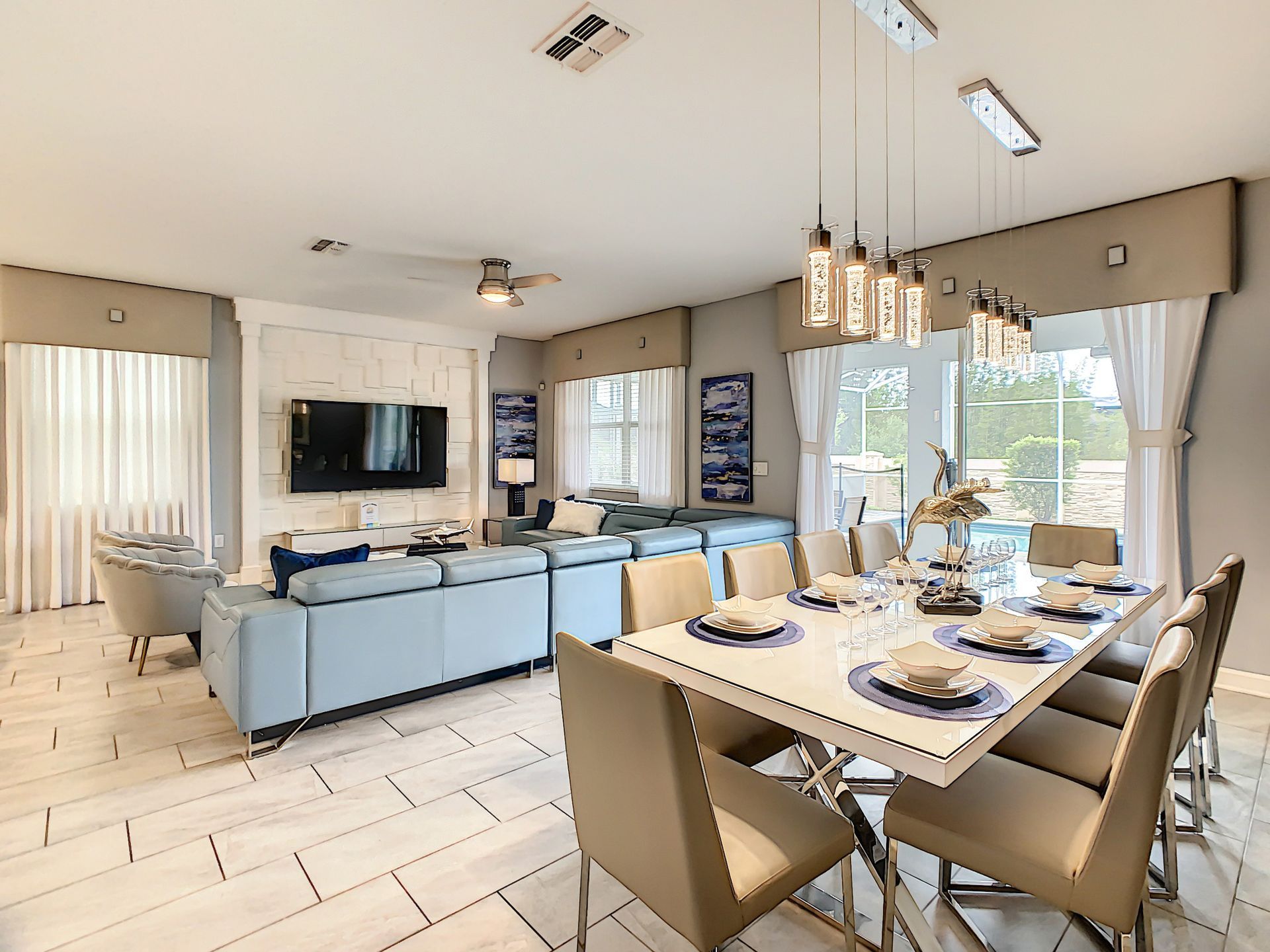 A living room with a dining table and chairs and a television.