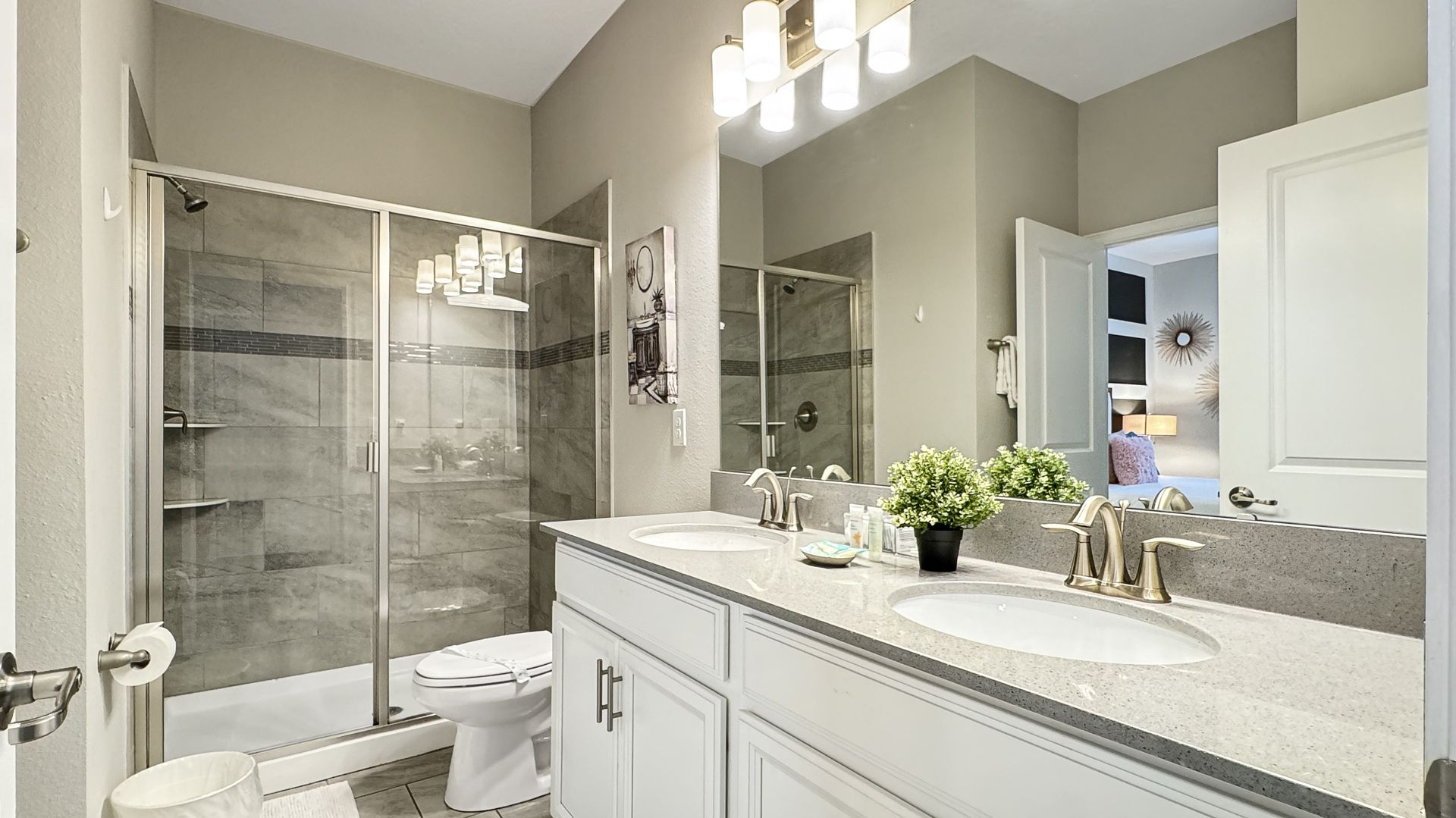 A bathroom with two sinks , a toilet , and a shower.