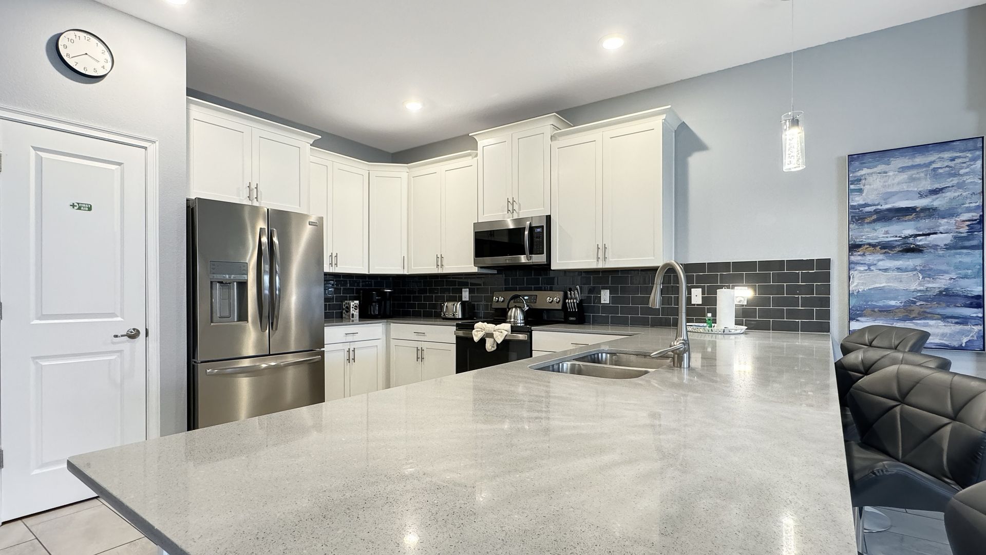 A kitchen with white cabinets and stainless steel appliances