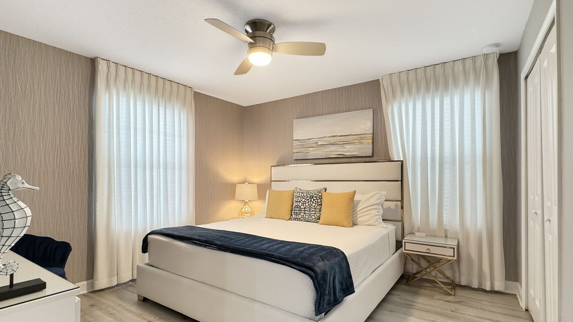 A bedroom with a king size bed and a ceiling fan.