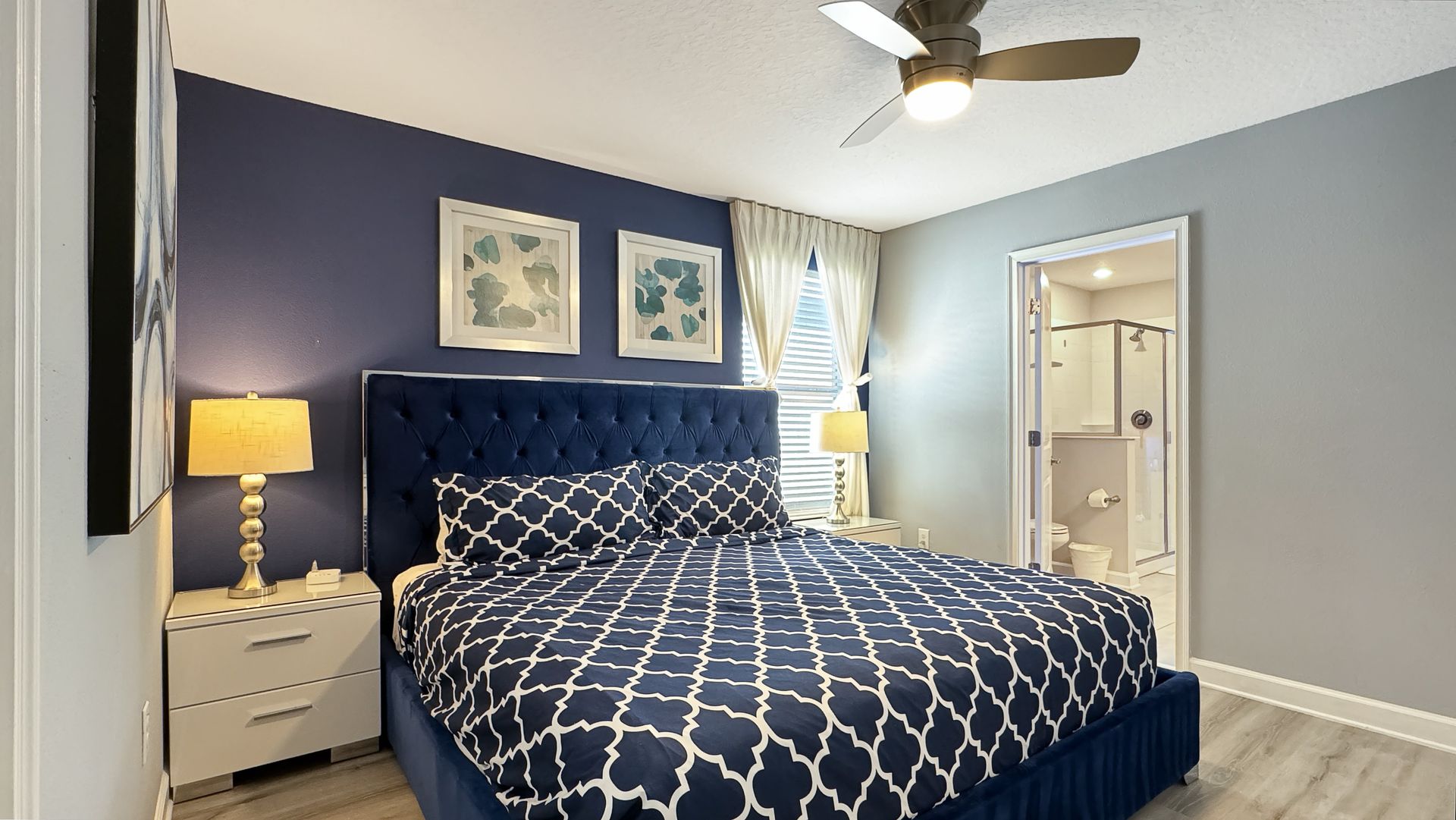 A bedroom with a king size bed and a ceiling fan.