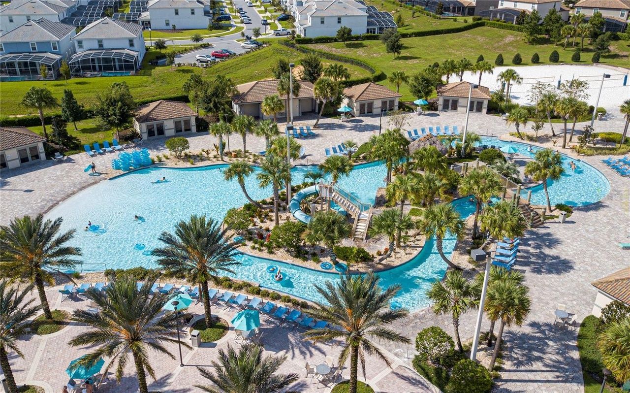 An aerial view of a large swimming pool surrounded by palm trees.