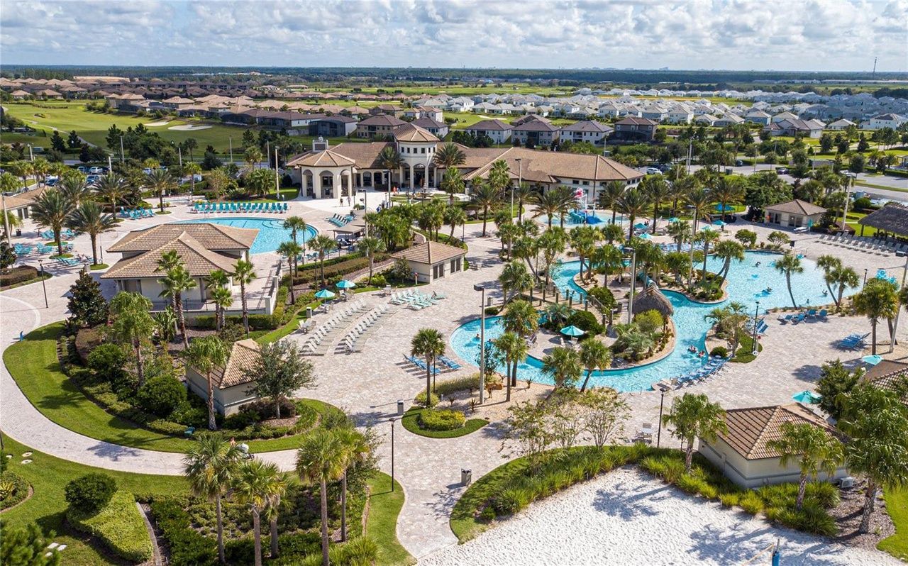 An aerial view of a large swimming pool surrounded by palm trees.