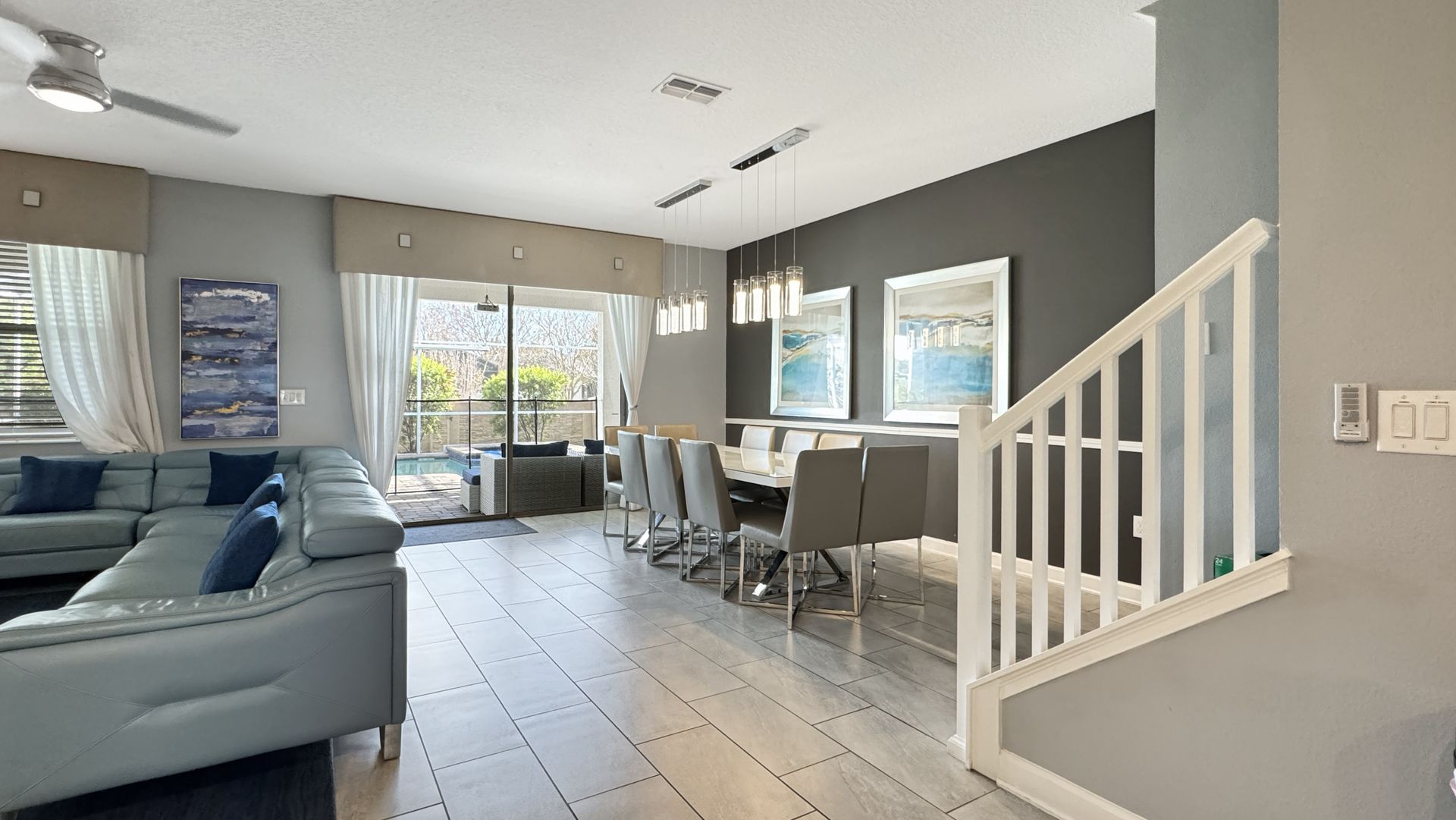 A living room filled with furniture and a staircase leading to the dining room.