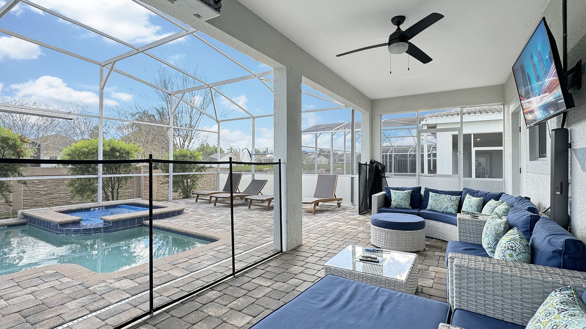 A patio with a swimming pool and a ceiling fan.