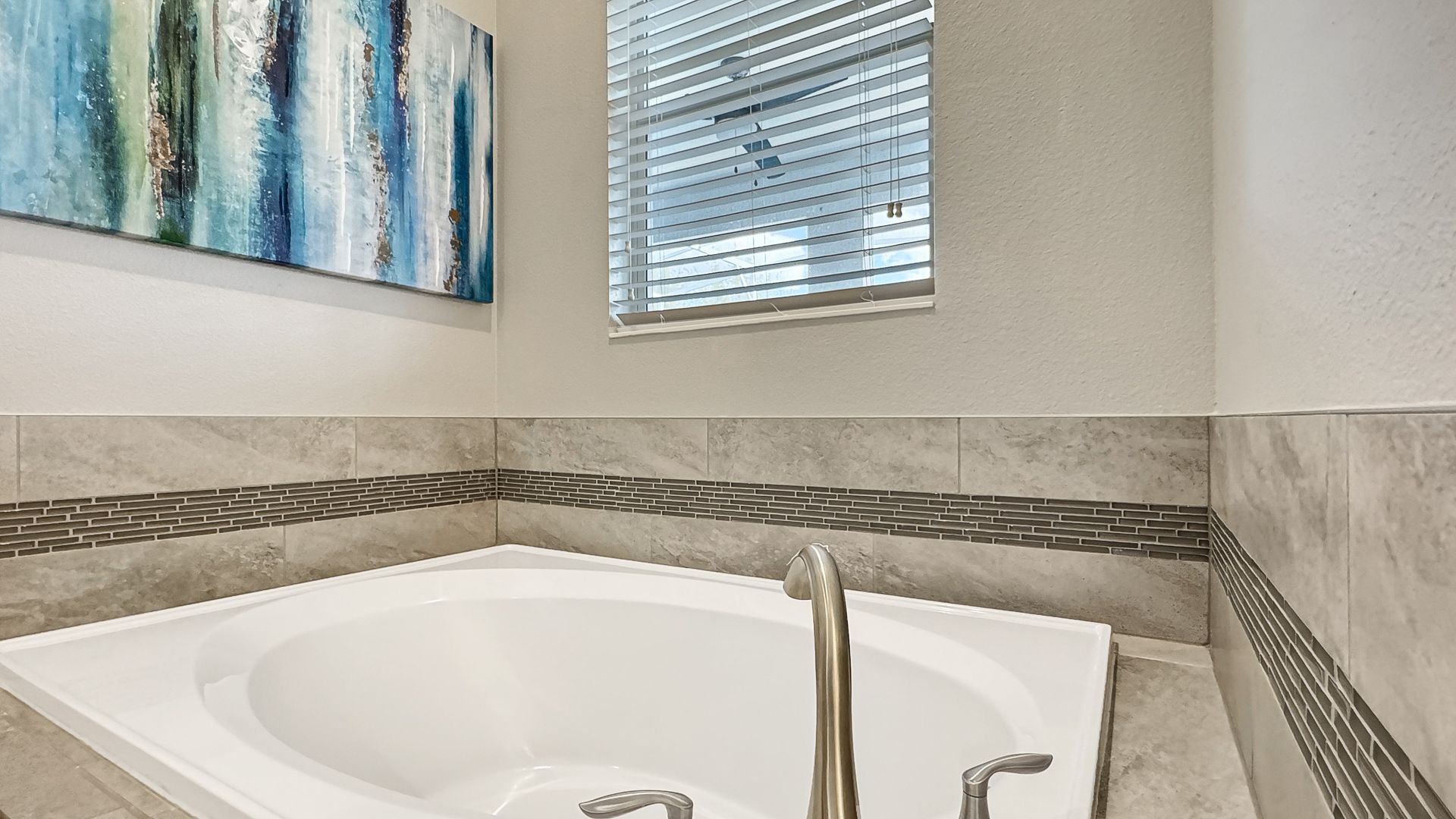 A bathroom with a jacuzzi tub and a window.