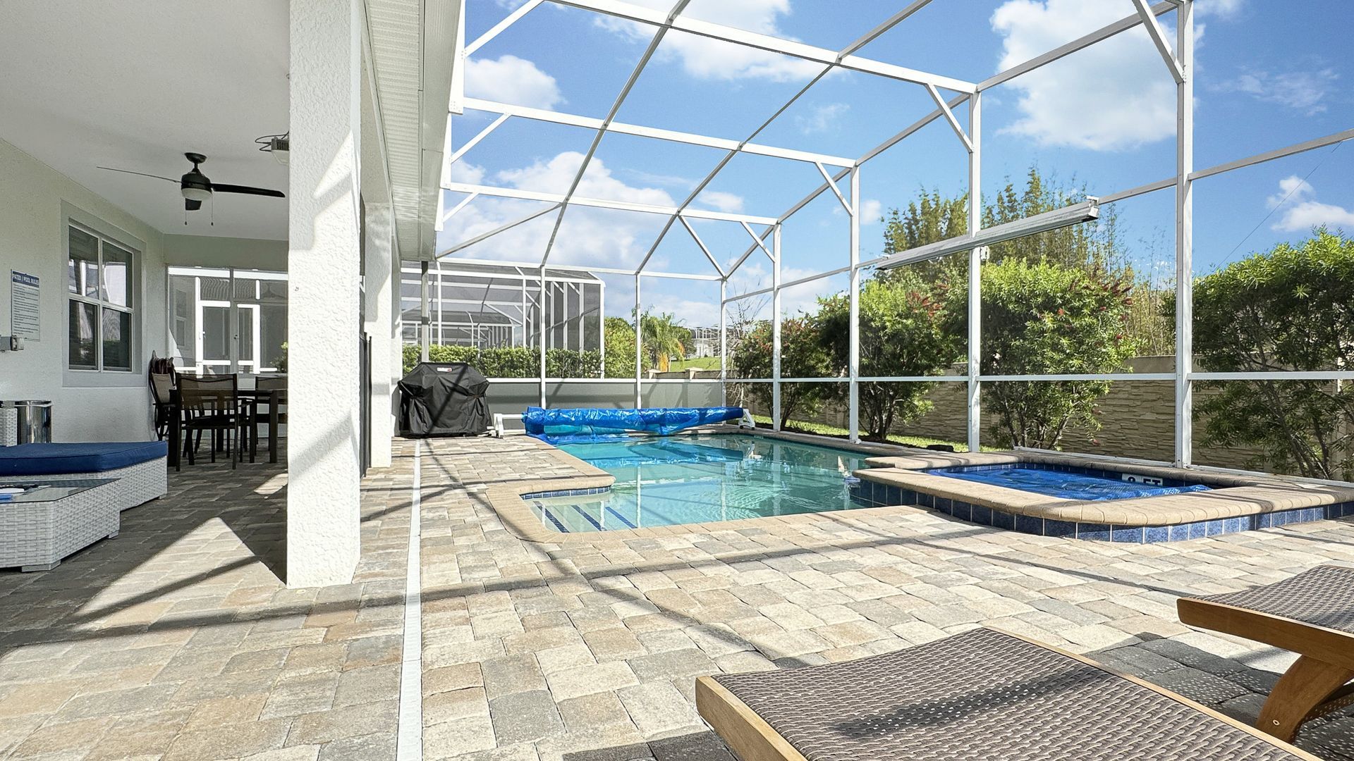 There is a large swimming pool in the backyard of a house.