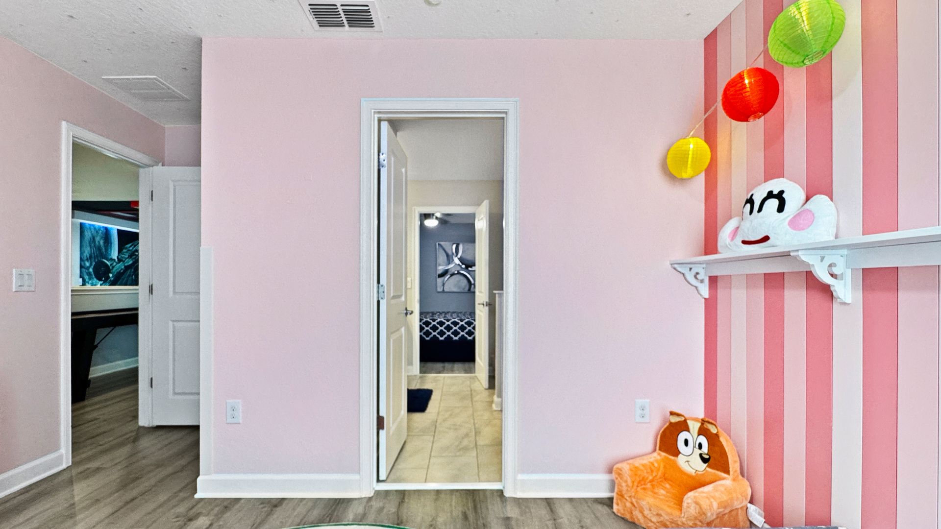 A room with pink walls and a monkey on the wall.