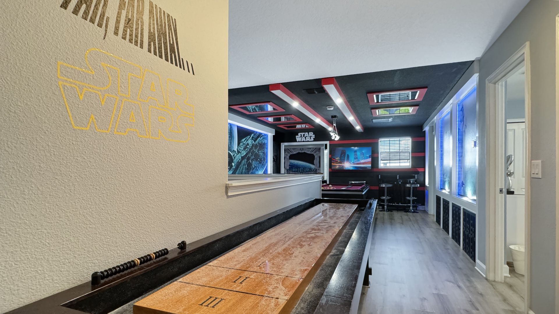 There is a shuffleboard table in the middle of the room.