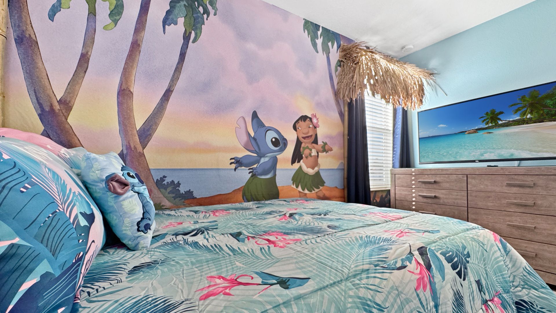A bedroom with a lilo and stitch mural on the wall.