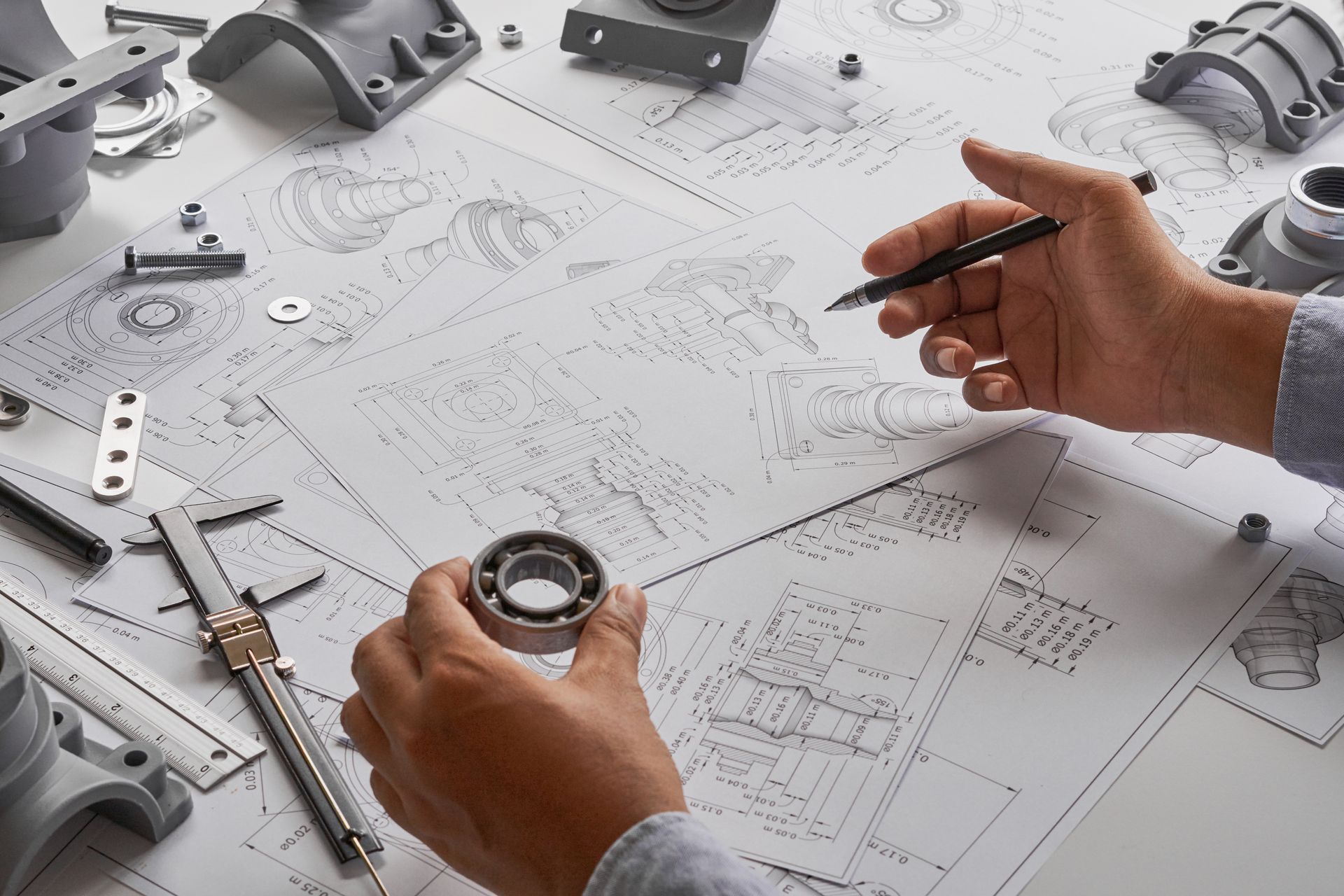 Una persona sostiene una bola de rodamiento y mira un dibujo.