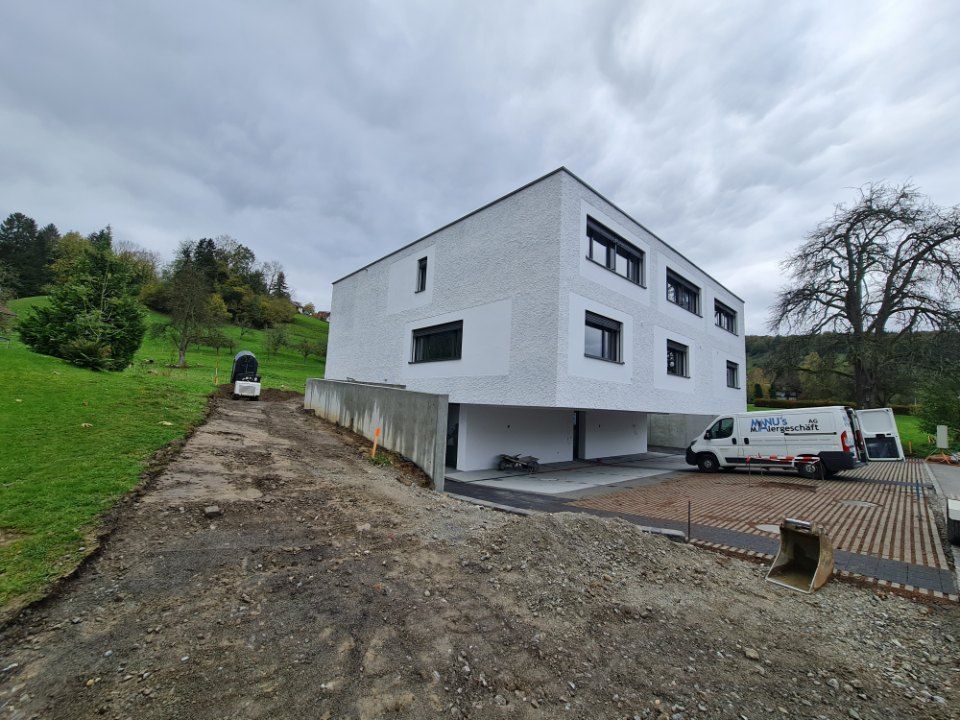 Fahrzeug der Manu's Malergeschäft AG vor einem Haus