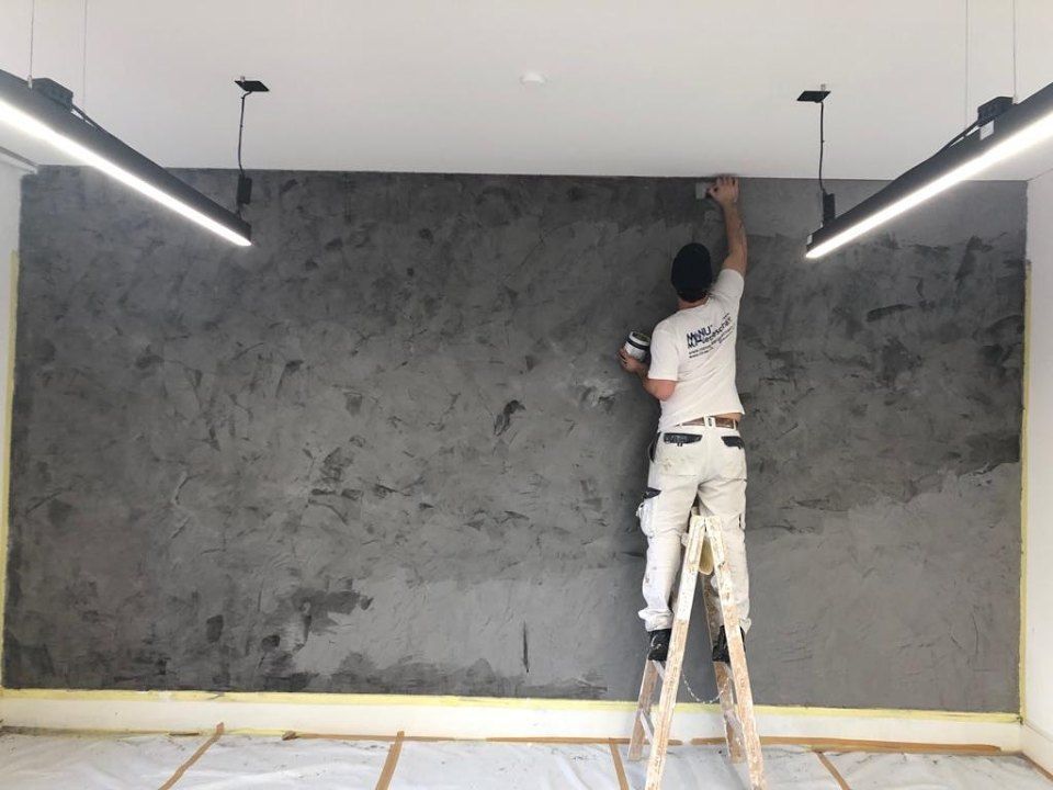 Maler der Manu's Malergeschäft AG arbeitet an einer Wand