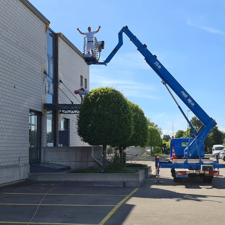 Mitarbeiter der Manu's Malergeschäft AG auf einer Hebebühne