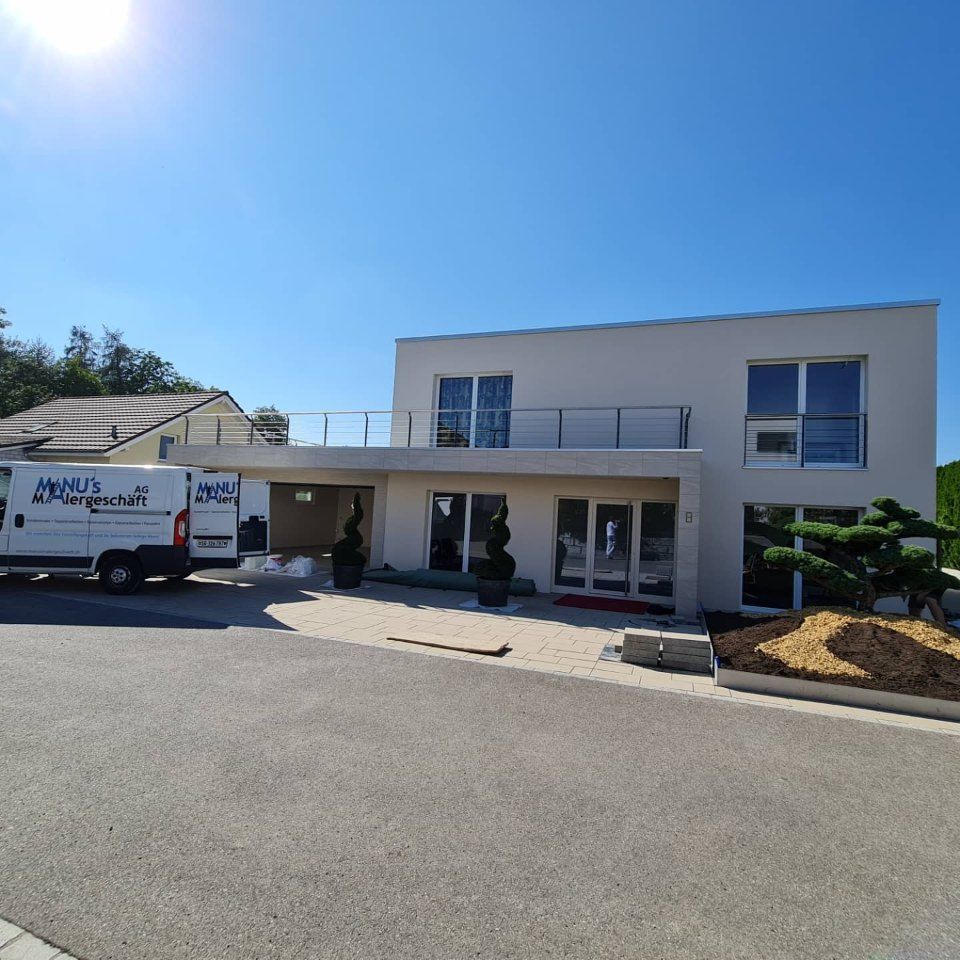 Fahrzeug der Manu's Malergeschäft AG vor einem Haus