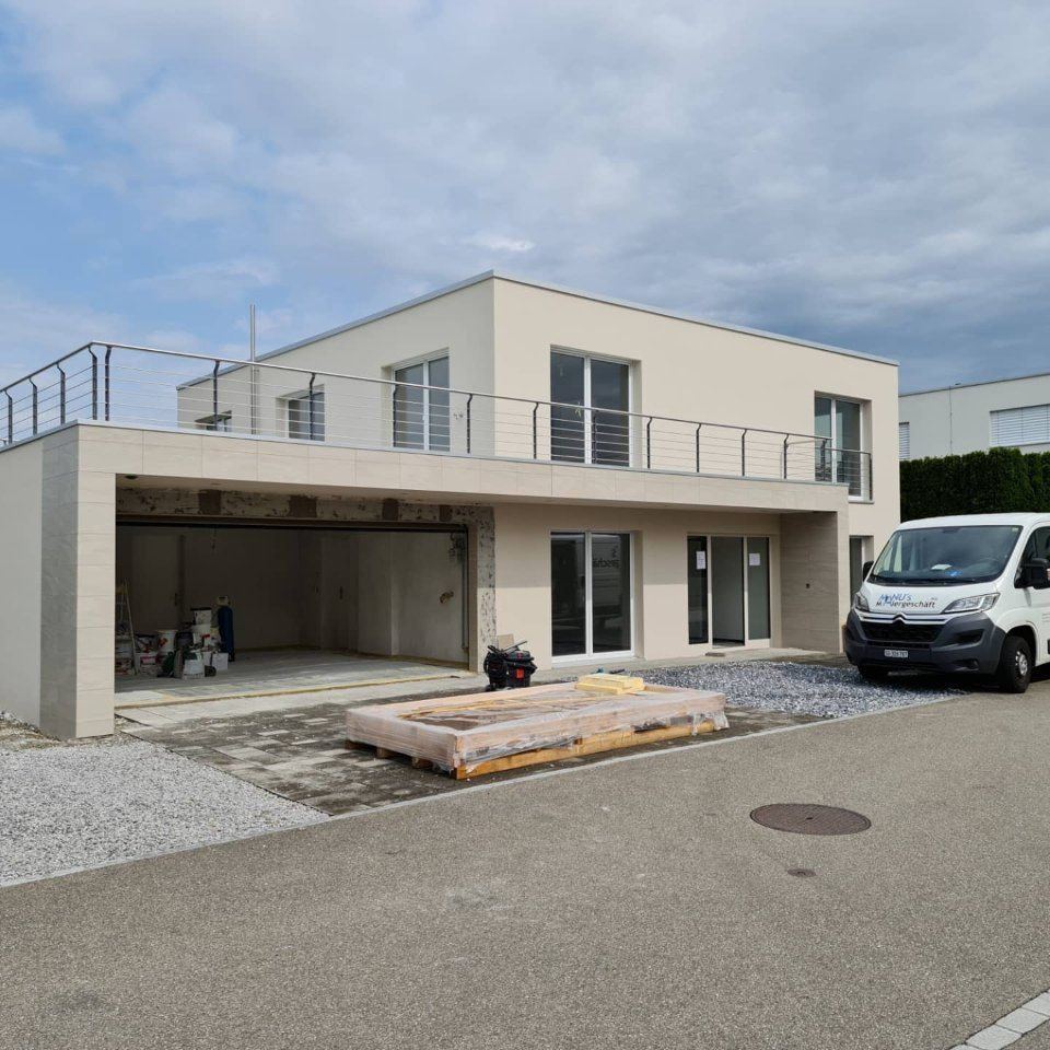 Fahrzeug der Manu's Malergeschäft AG vor einem Haus