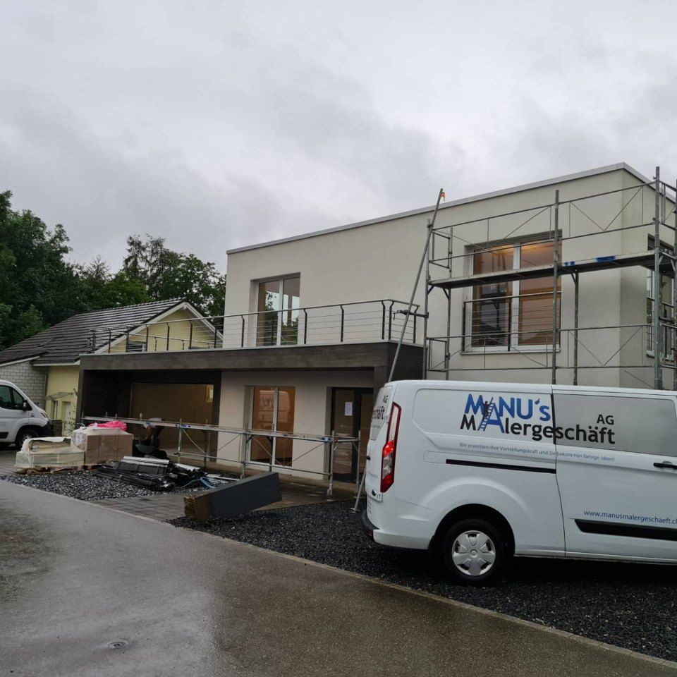 Fahrzeug der Manu's Malergeschäft AG vor einem Haus
