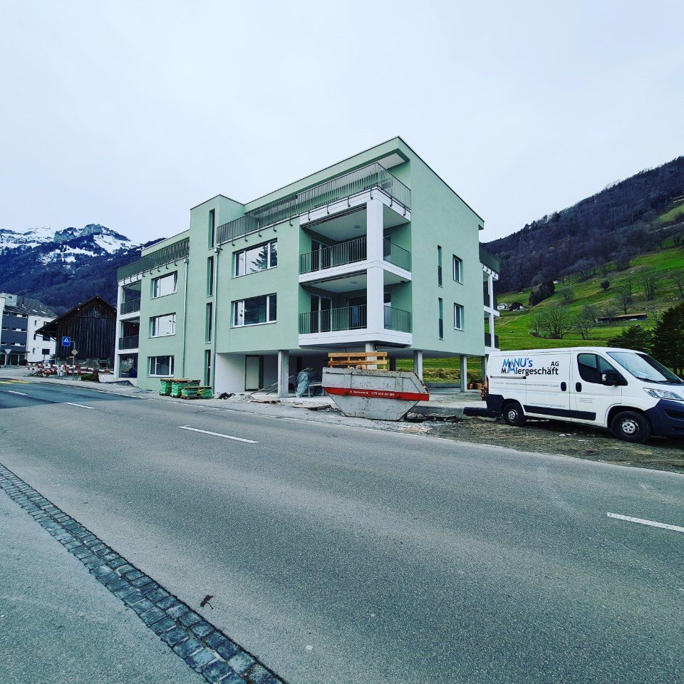 Fahrzeug der Manu's Malergeschäft AG vor einem Wohngebäude