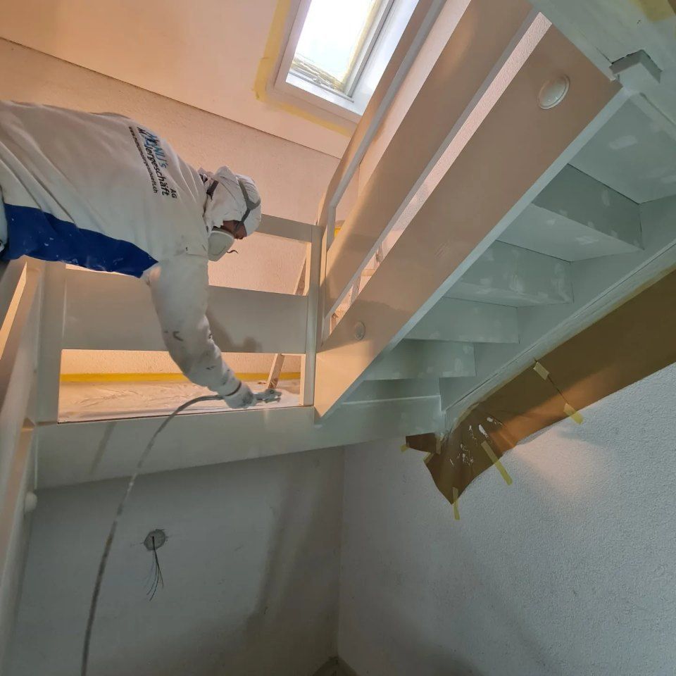 Maler der Manu's Malergeschäft AG arbeitet an einer Treppe