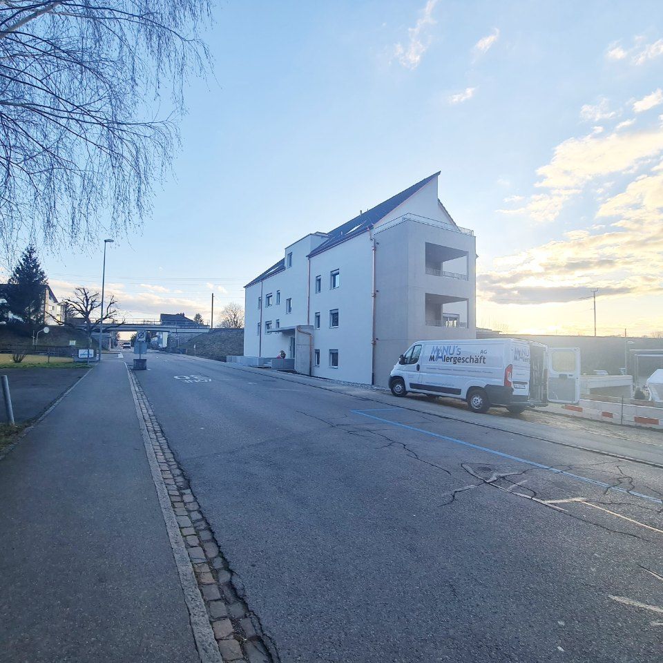 Fahrzeug der Manu's Malergeschäft AG vor einem Wohngebäude