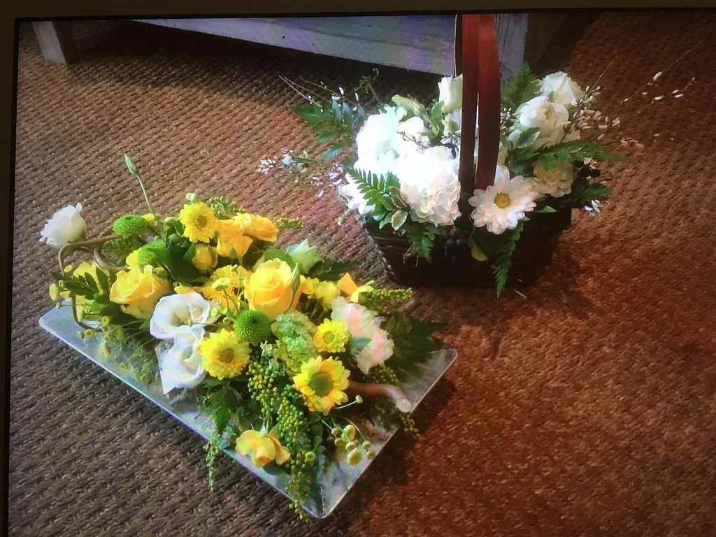 Deux compositions florale : une jaune et blanche, et une blanche et verte dans un panier