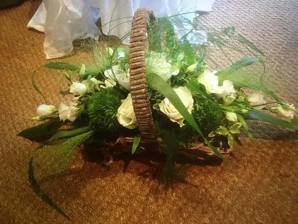 Composition florale blanche et verte, dans un panier