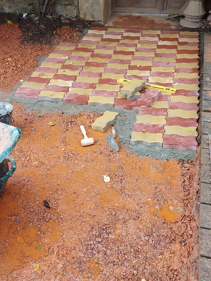 Construction d'un chemin avec des pavés autobloquants rouges et jaunes.