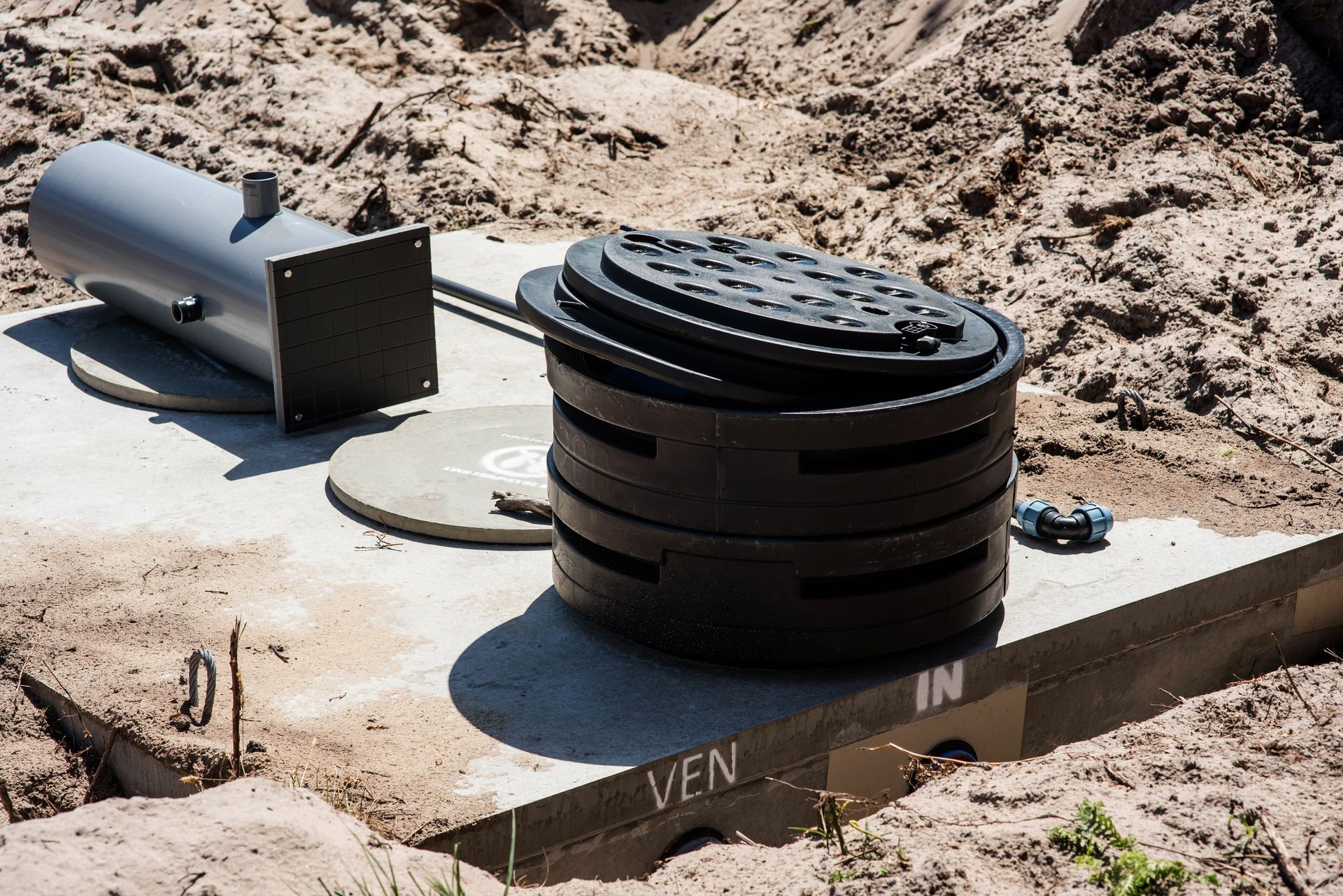 Installation d'un système septique en sol sableux, comprenant une fosse, une colonne montante et un évent.