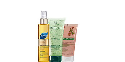 Trois produits de soin pour la peau : un flacon vaporisateur jaune, un tube de lotion vert et un tube de crème rose.