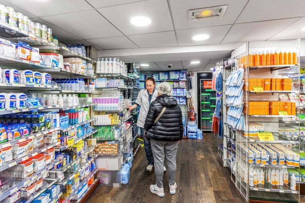 Deux personnes dans une allée bien éclairée de la pharmacie
