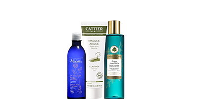 Trois flacons de soins Cattier dans un emballage bleu, blanc et turquoise sur fond blanc