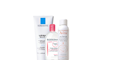 Trois flacons et tubes de produits de soin de la peau sur fond blanc