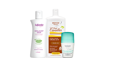 Produits de soin assortis : flacons blancs et pot turquoise sur fond blanc.