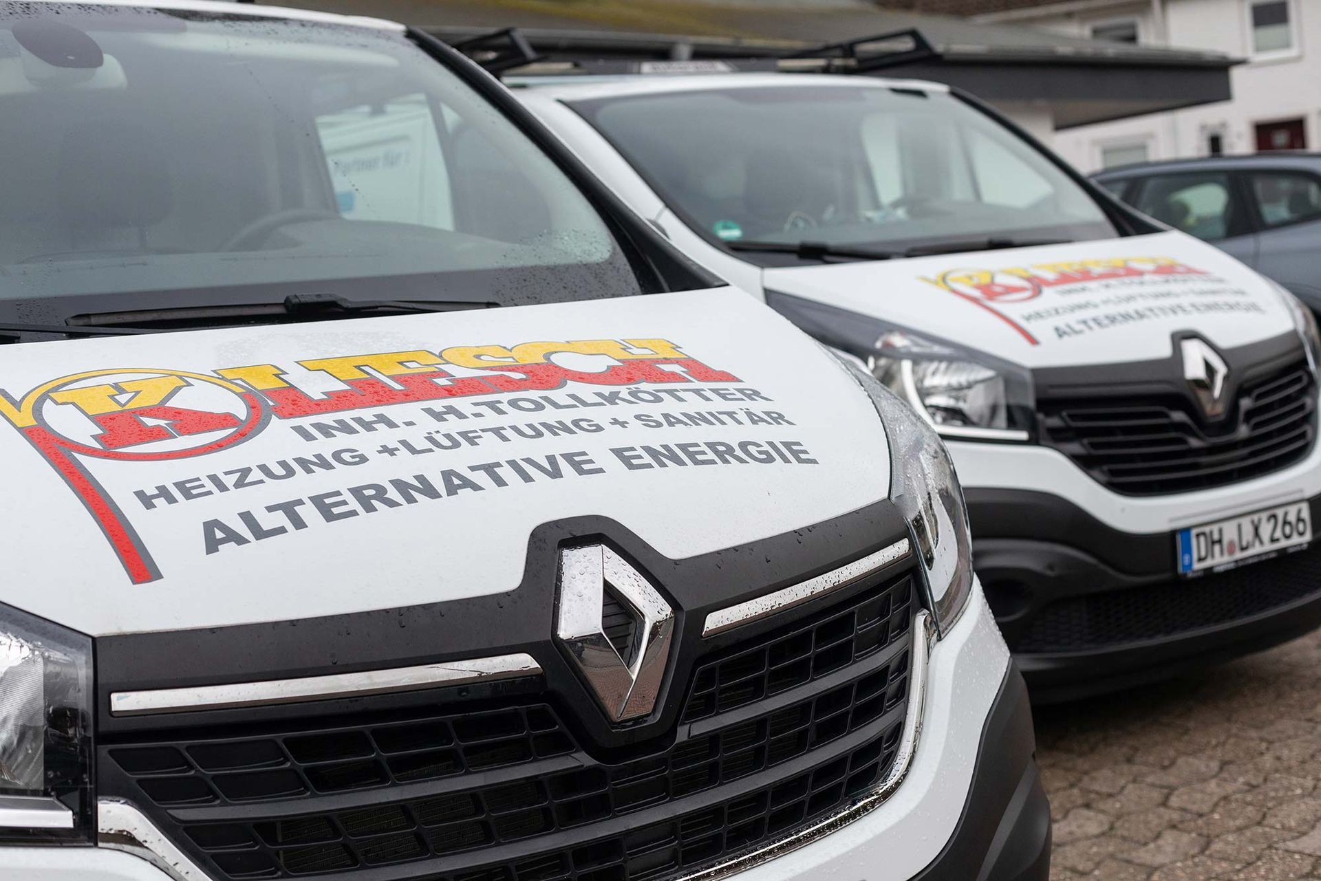 Zwei weiße Lieferwagen stehen nebeneinander auf einem Parkplatz.
