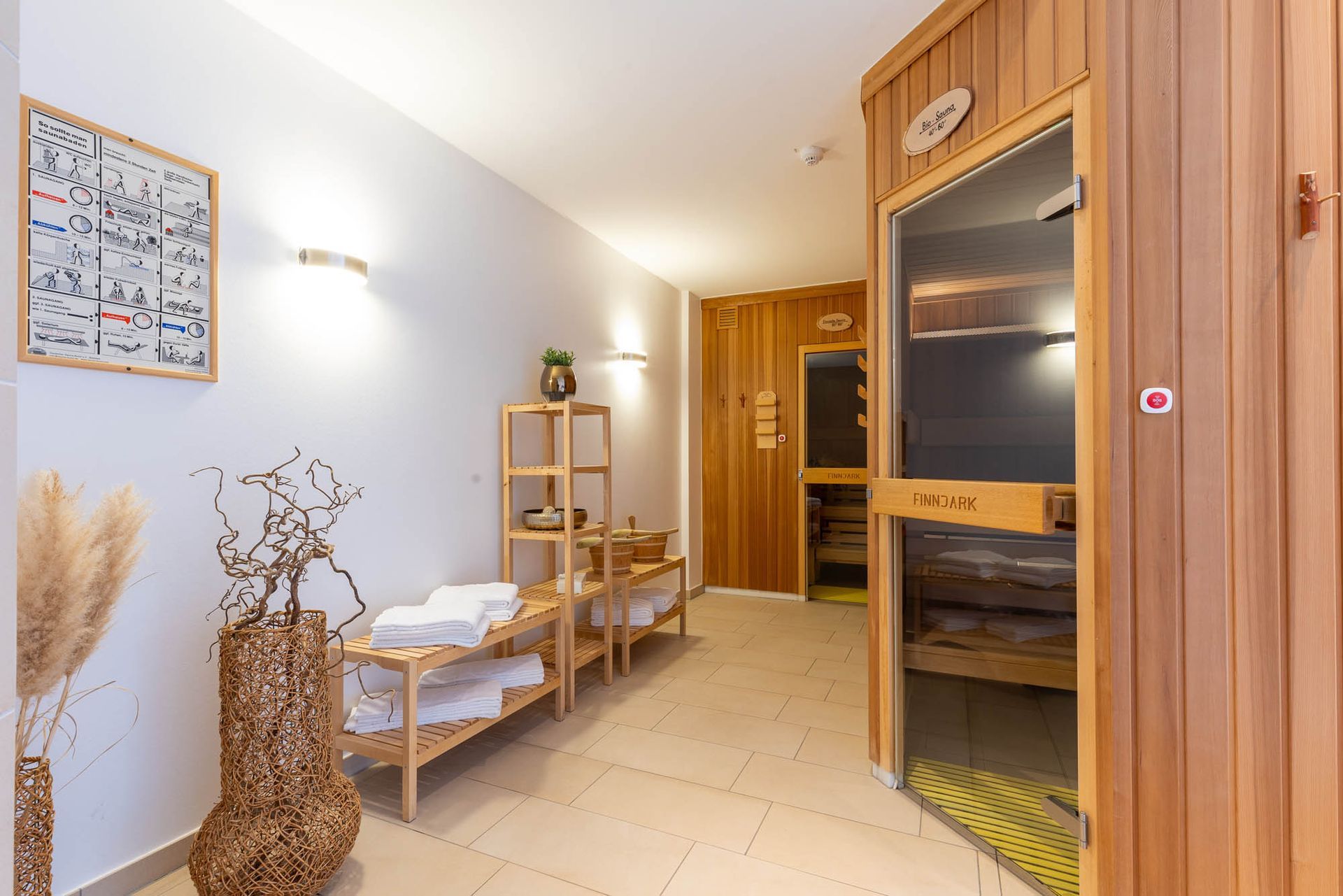 Eine Holzsauna mit Glastür und Handtüchern auf Regalen.