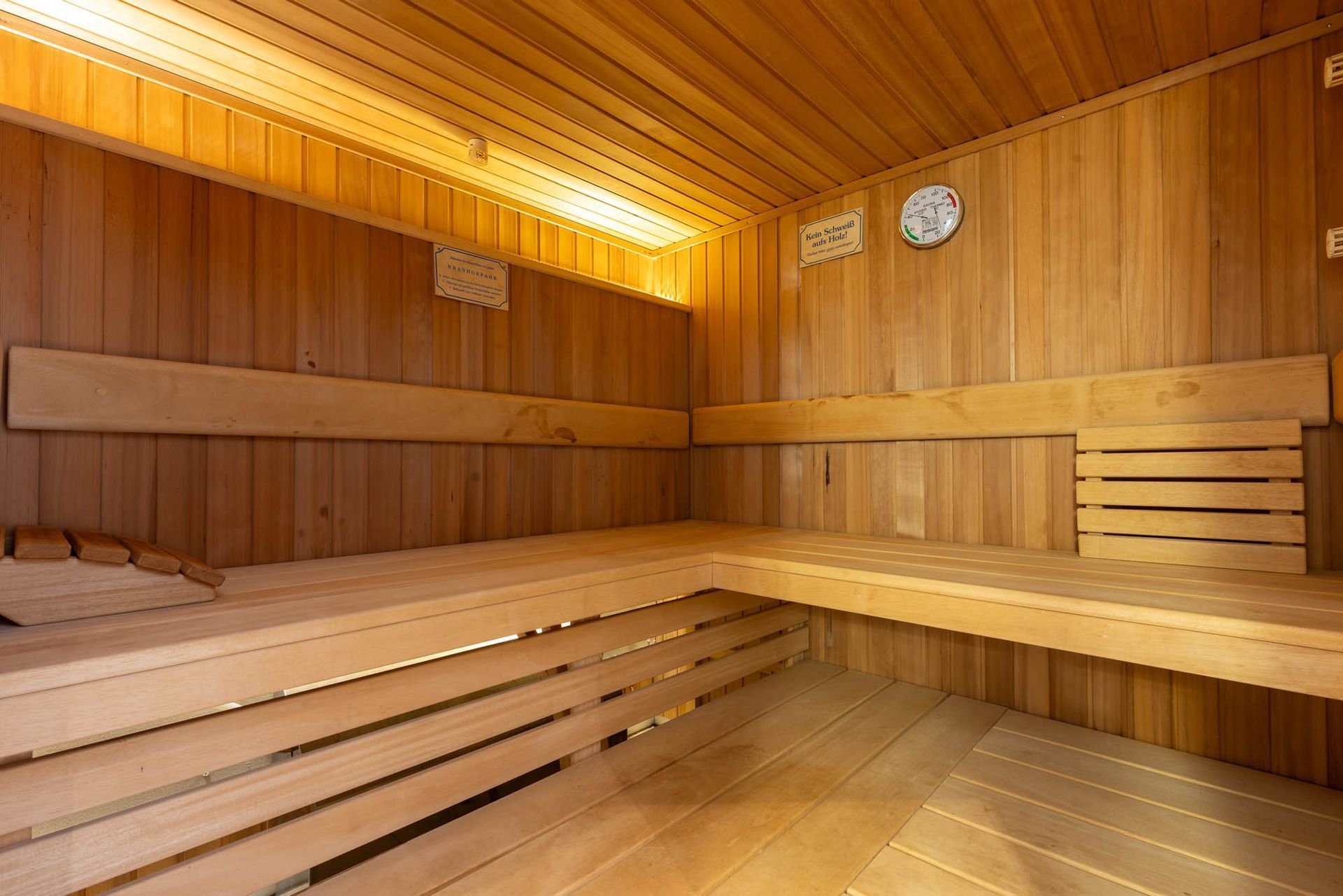 Das Innere einer Holzsauna mit einer Uhr an der Wand.