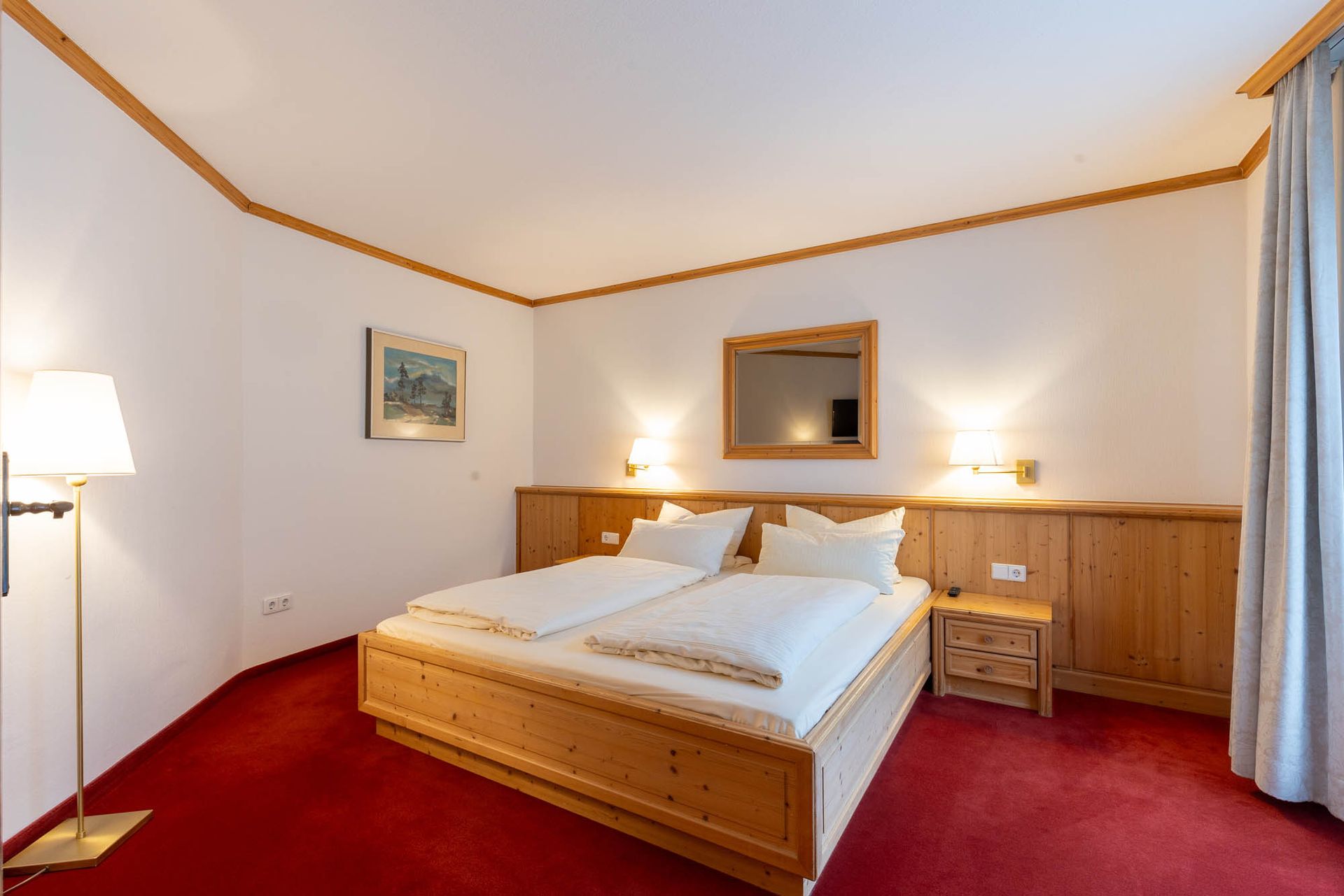 Ein Hotelzimmer mit einem großen Bett und einem roten Teppich.