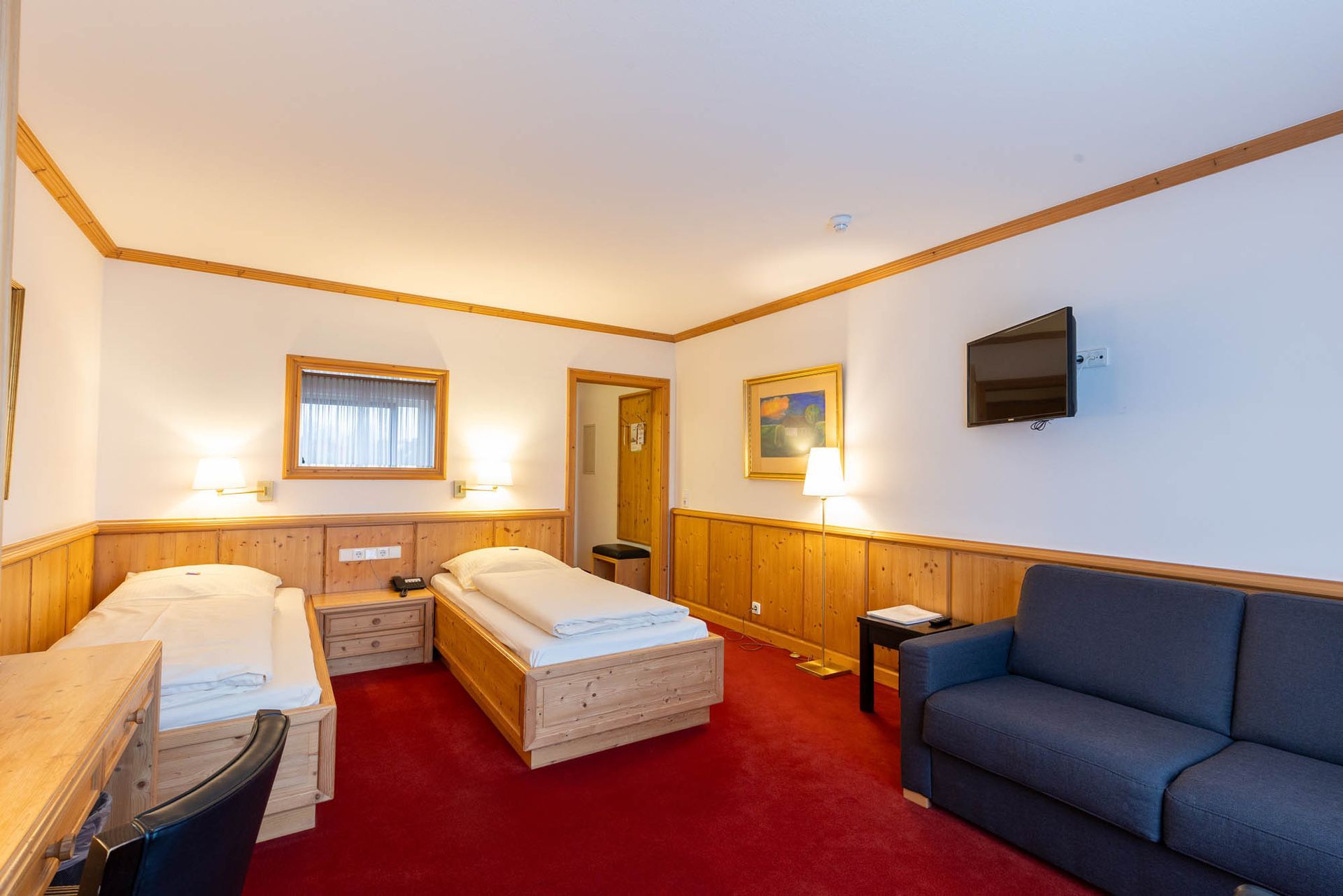 Ein Hotelzimmer mit zwei Betten und einer Couch.