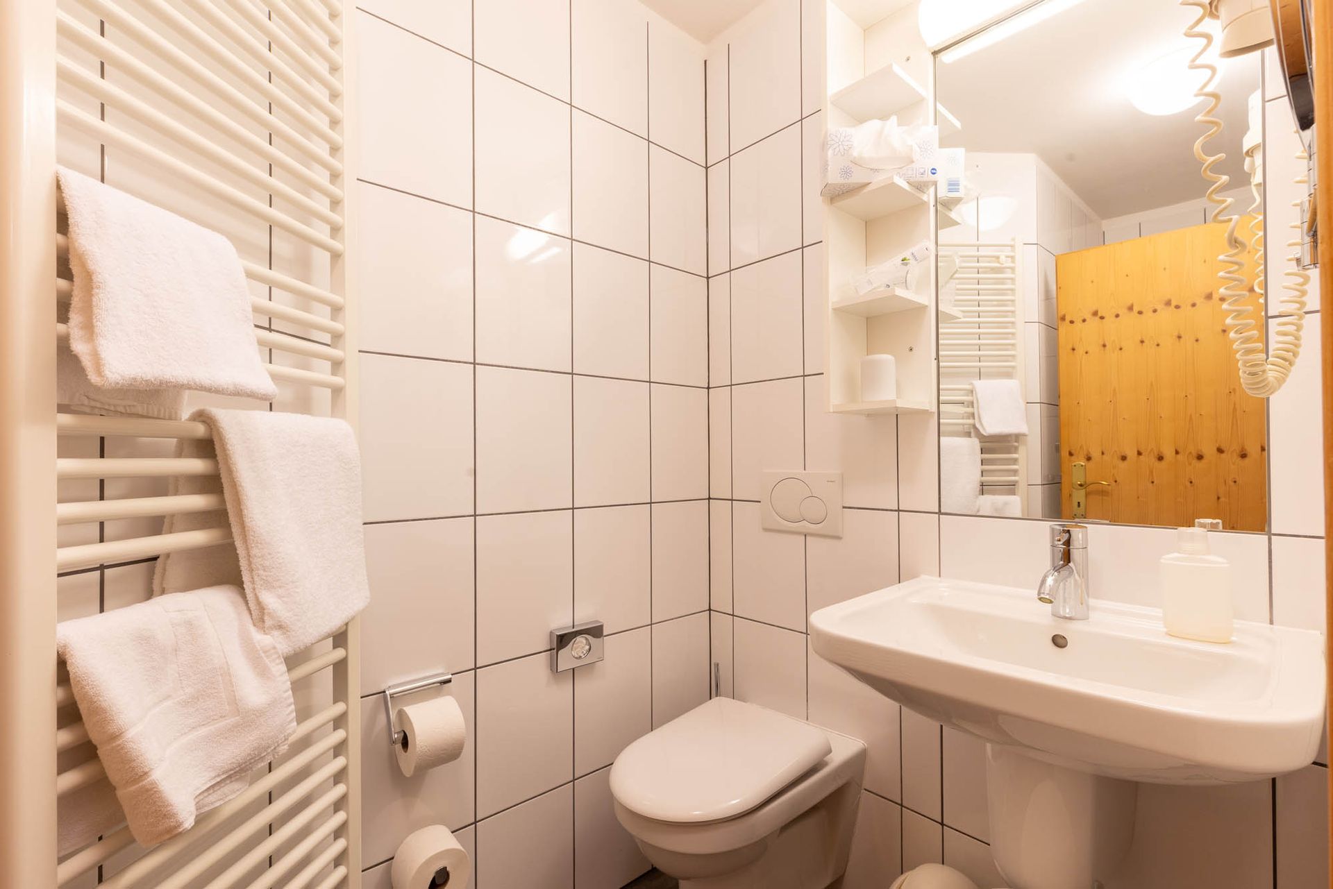 Ein Badezimmer mit Toilette, Waschbecken und Spiegel.