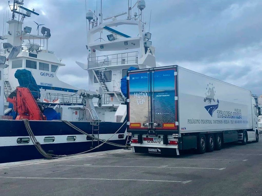 Un camión está estacionado frente a un gran barco.