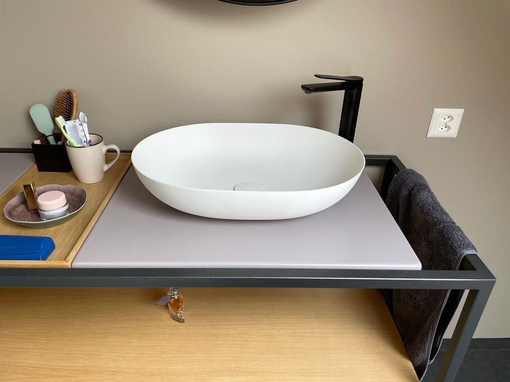 Ein Waschbecken steht auf einer Holzablage.