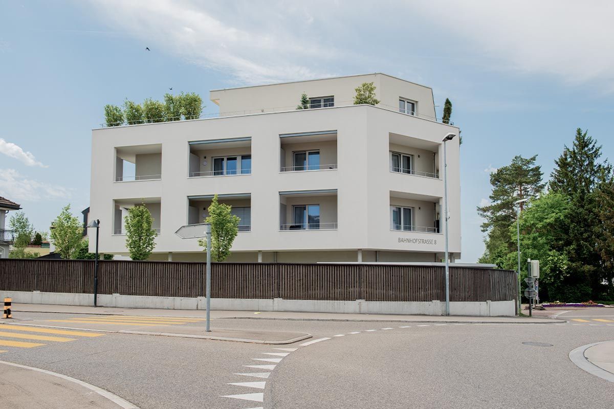 Ein großes weißes Gebäude mit einem Zaun davor