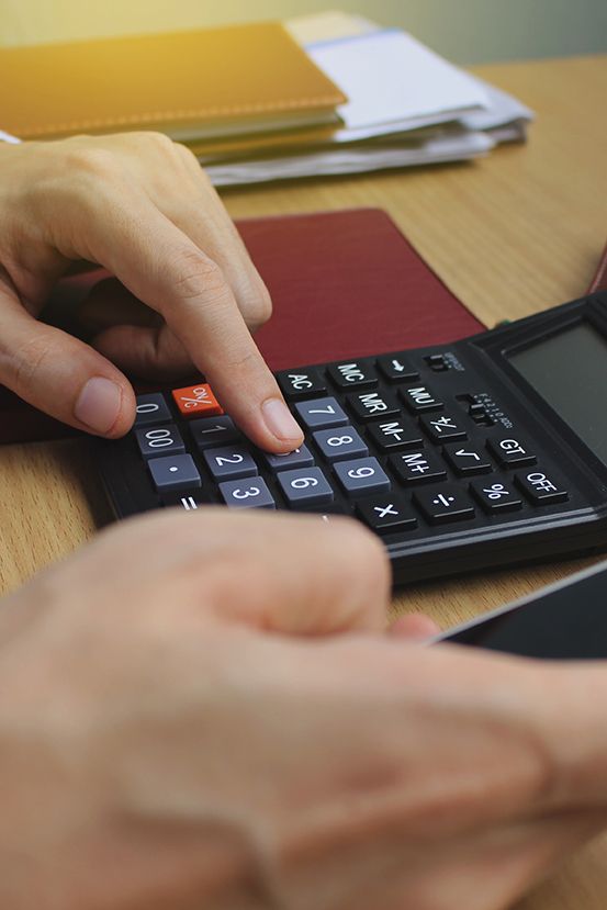 Personne faisant des calculs à l'aide d'une calculatrice