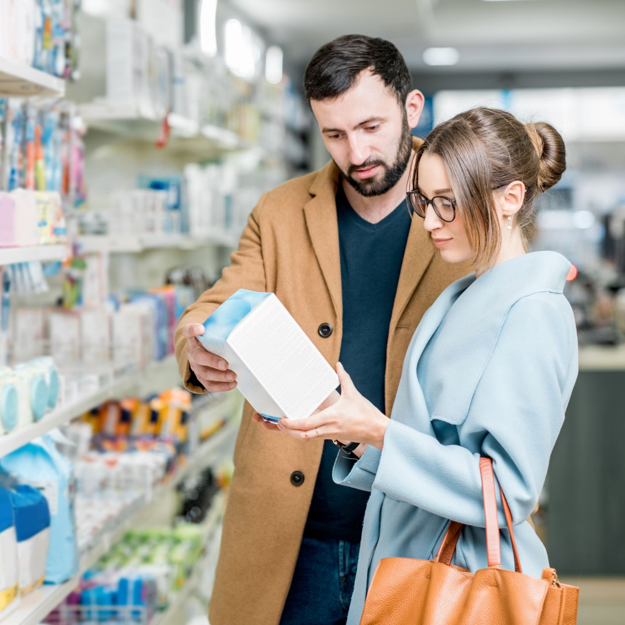 Un couple consulte un produit de parapharmacie.