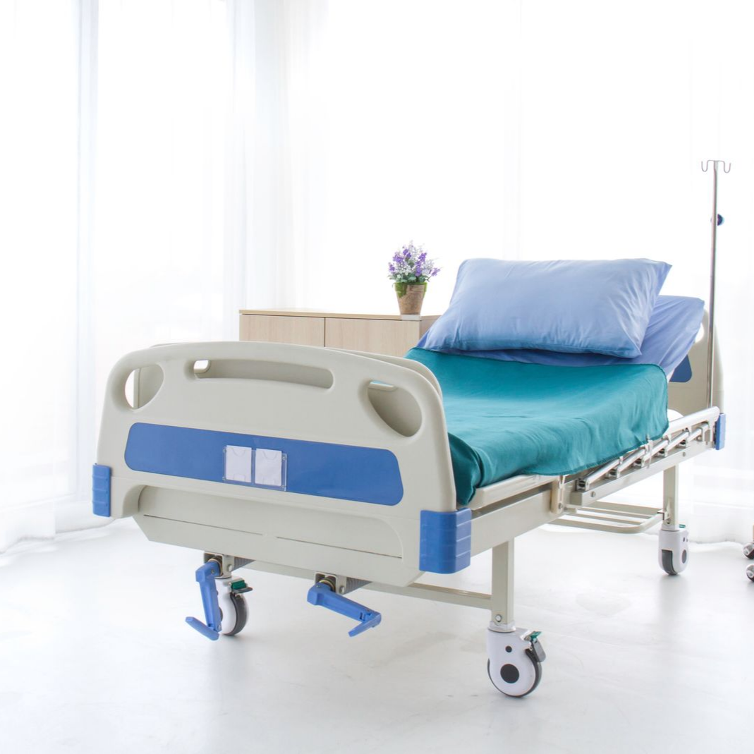 Un lit médicalisé avec des draps bleus.