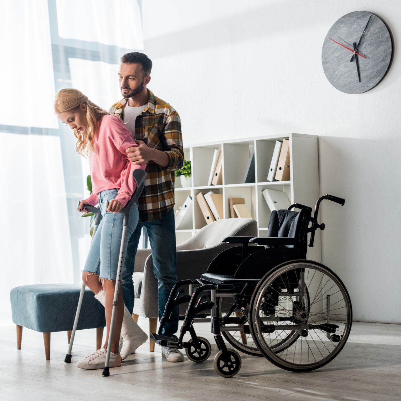 Un homme qui aide une femme à marcher avec des béquilles.