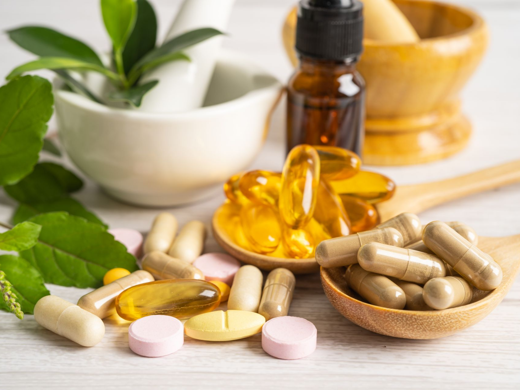 Des compléments alimentaires et herbes avec un mortier et un pilon.