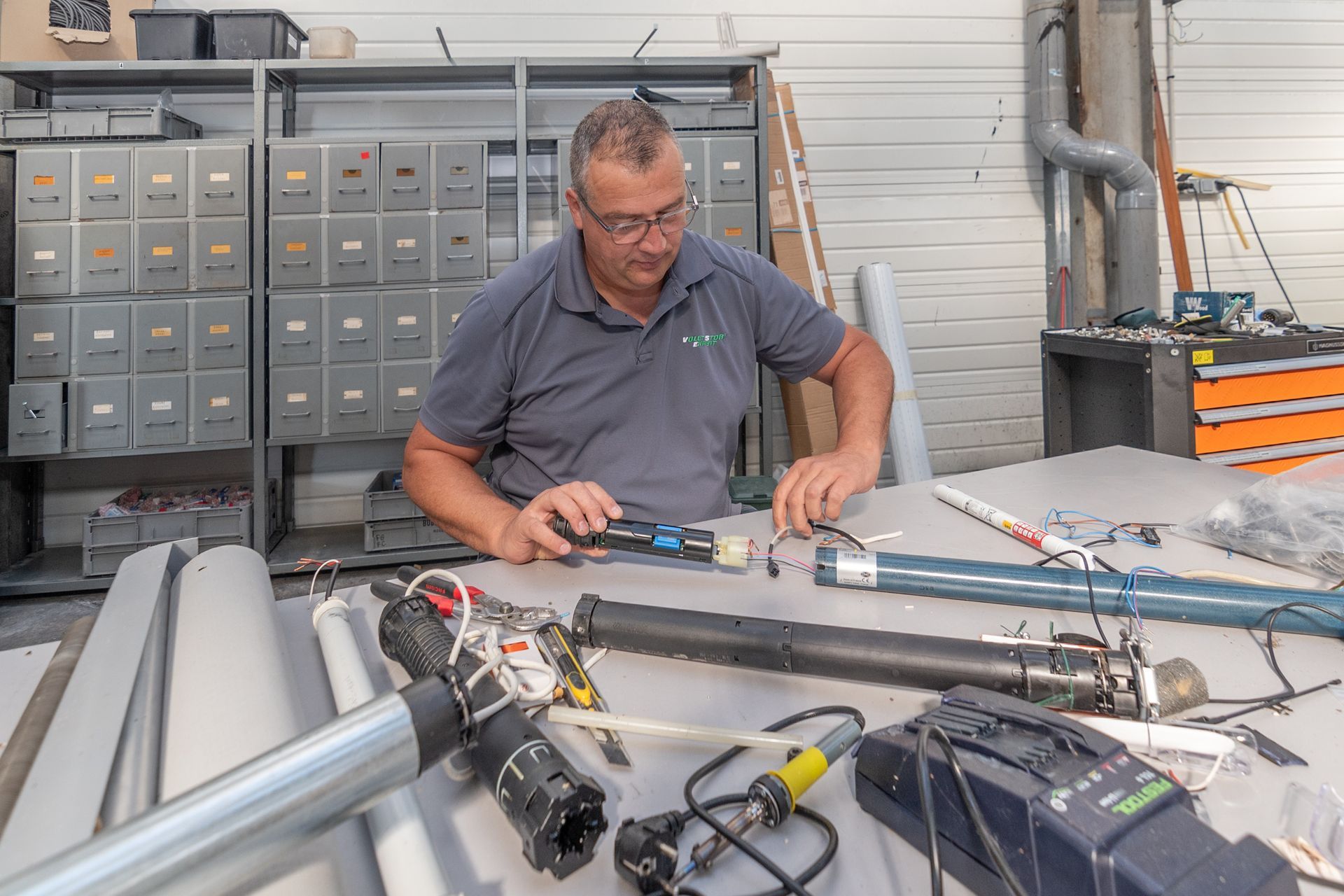 Homme travaillant sur des composants électroniques à un établi.