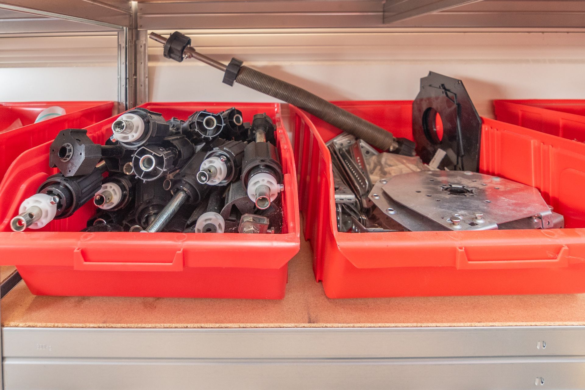 Des bacs rouges qui contiennent diverses pièces mécaniques.