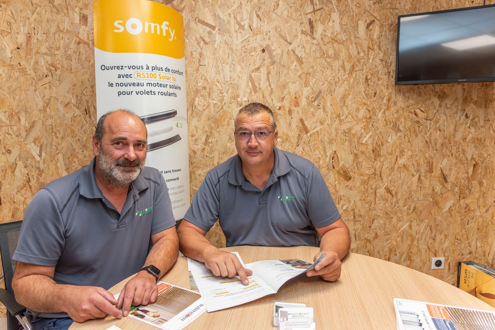 Deux hommes assis à une table qui consultent un document